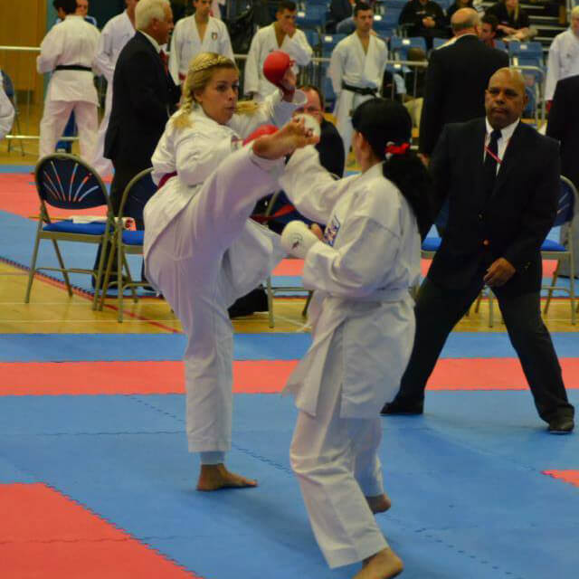 Female karate kumite fighter kicking