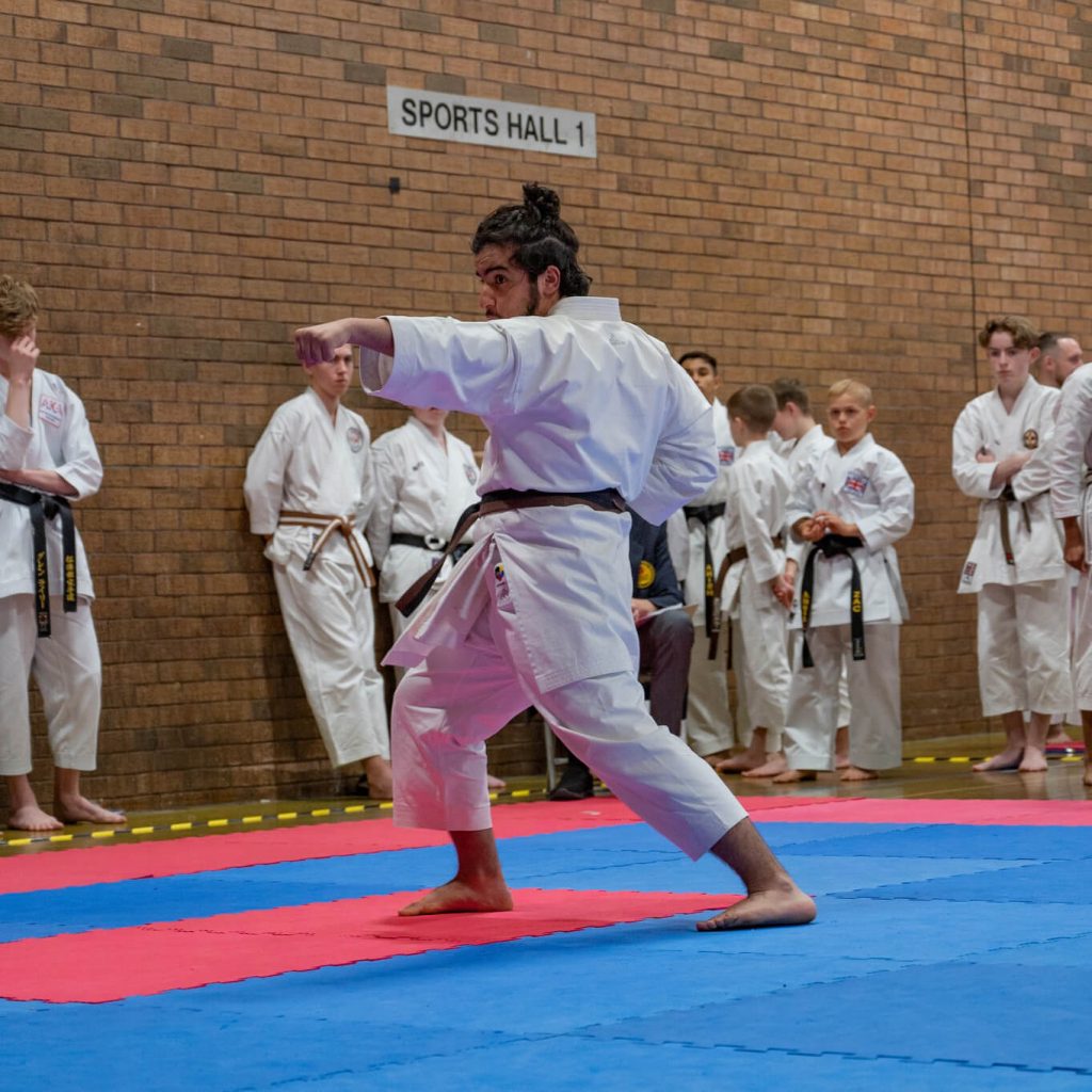 Young male karate student performing kata